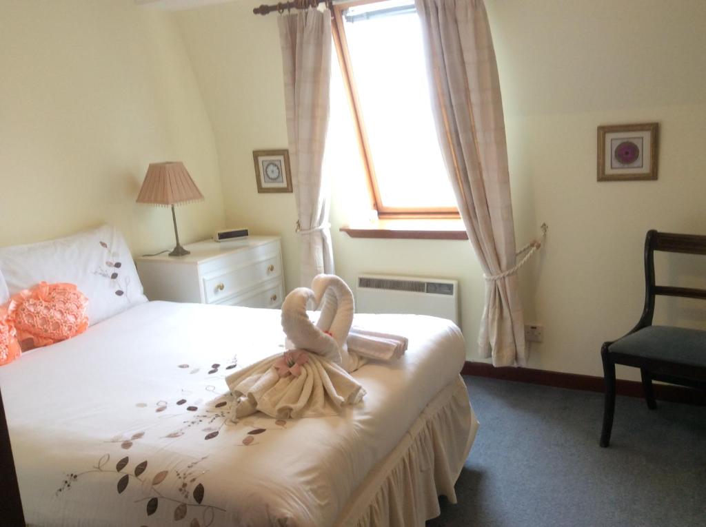 a bedroom with a bed with two swans on it at Connel Court Apartments in Inverness