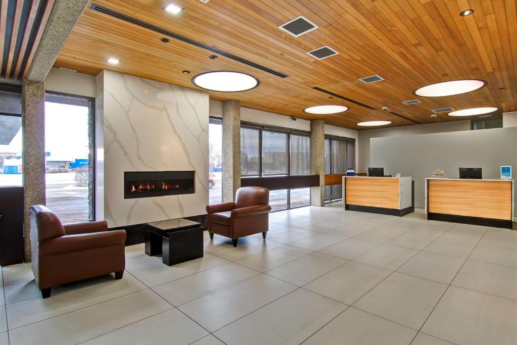 vestíbulo de oficina con sillas y chimenea en Best Western Cedar Park Inn en Edmonton