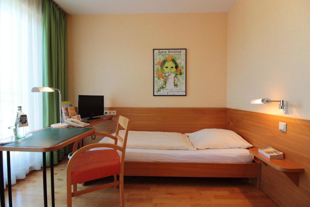 A bed or beds in a room at An der Persiluhr Stadt-gut-Hotel