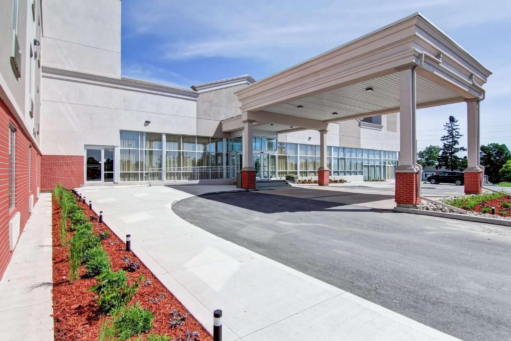 a large building with a walkway in front of it at Best Western Plus Bowmanville in Bowmanville