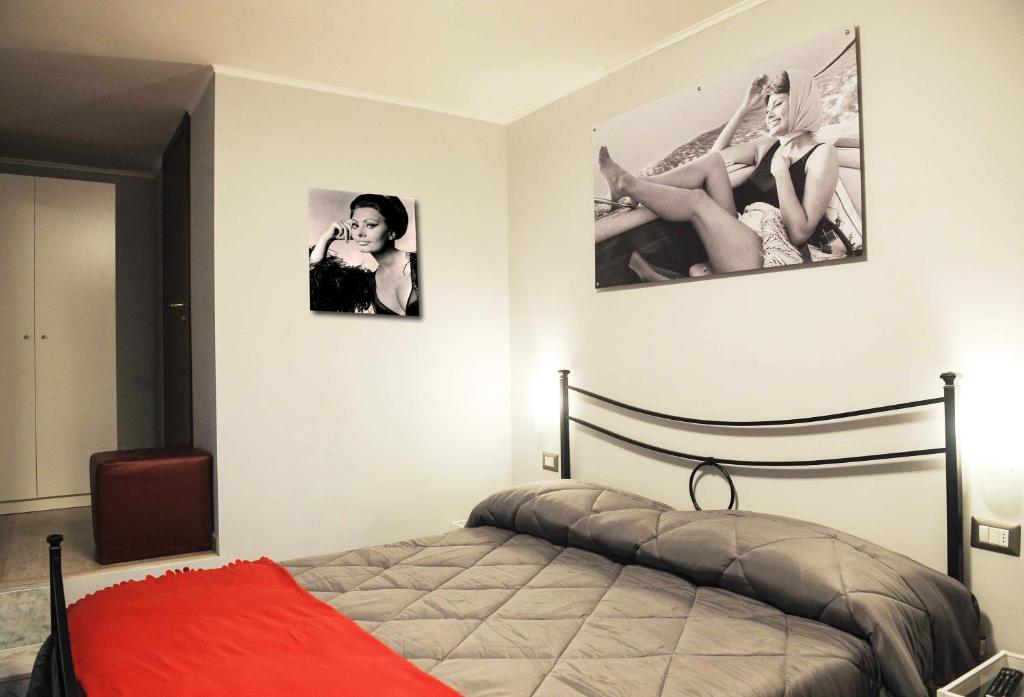 a bedroom with a bed and two pictures of legs on the wall at Obelisco in Naples