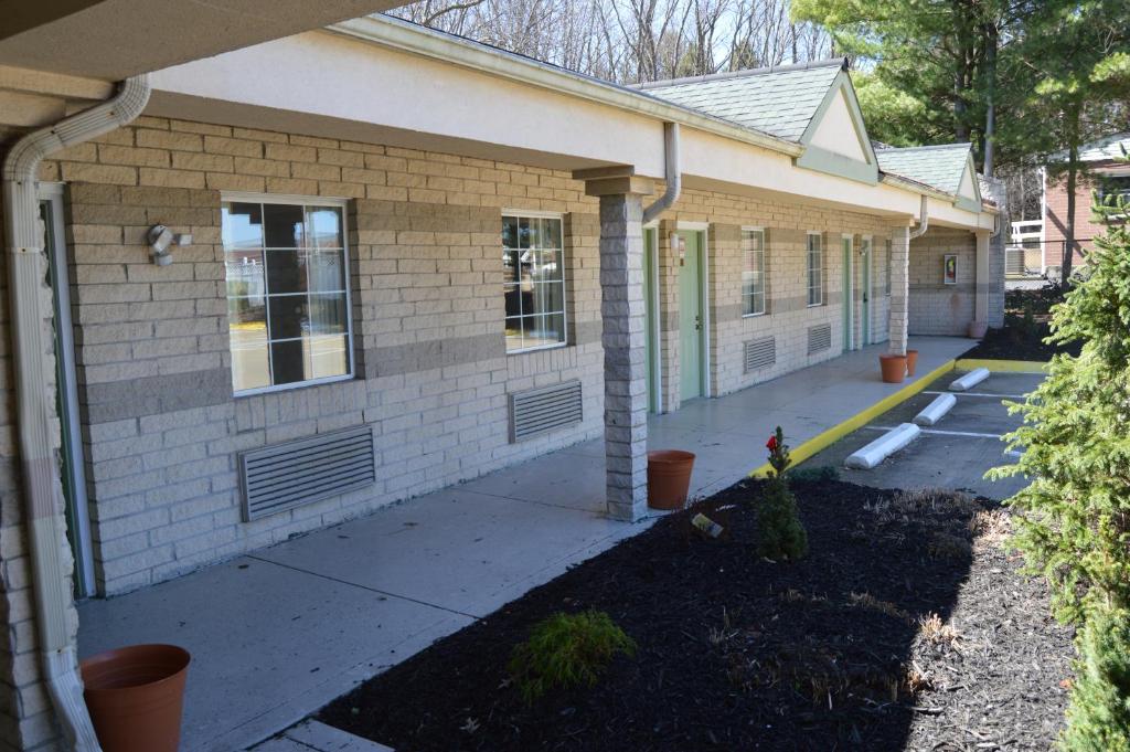 a brick house with a sidewalk in front of it at Economy Inn Cuyahoga Falls in Cuyahoga Falls