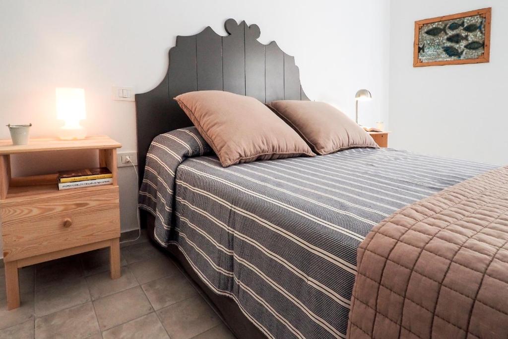 1 dormitorio con 1 cama grande y cabecero de madera en siciliacasevacanze - La Mancina, en Marina di Ragusa