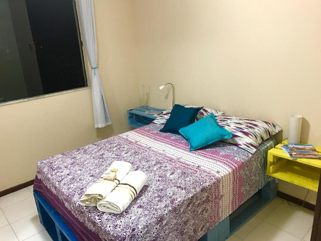 um quarto com uma cama com toalhas em Quarto em Vilas do Atlântico em Lauro de Freitas