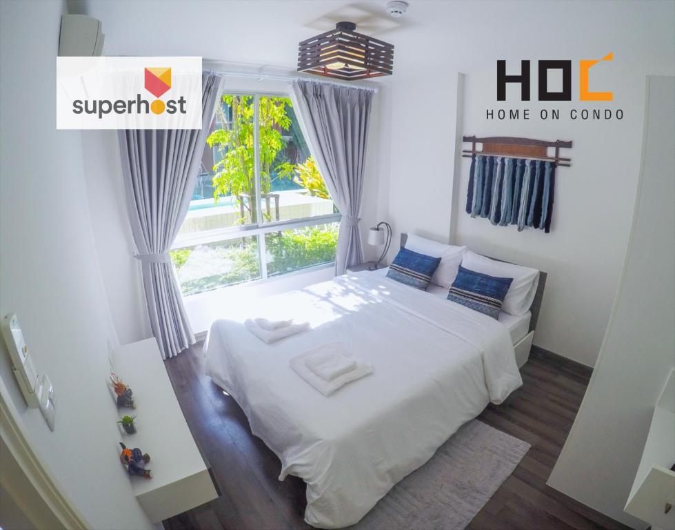 ein Schlafzimmer mit einem weißen Bett und einem Fenster in der Unterkunft HOC2 Apartment Santitham Chiang Mai in Chiang Mai