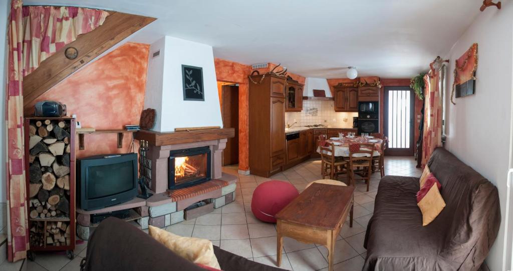 sala de estar con TV y chimenea en Gîte Des Prés Berthe, en Le Clerjus