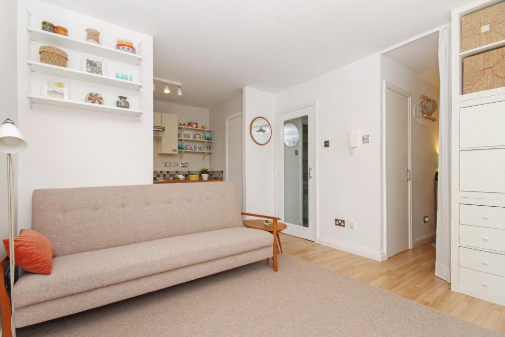 a living room with a couch and a clock on the wall at City Centre Haven Apartments in Edinburgh