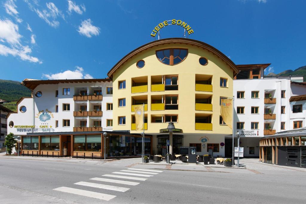a large yellow building on the corner of a street at Hotel Liebe Sonne in Sölden