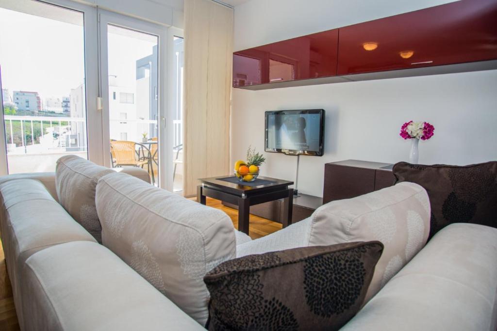 sala de estar con sofá blanco y TV en Antonio Apartments on the beach, en Split
