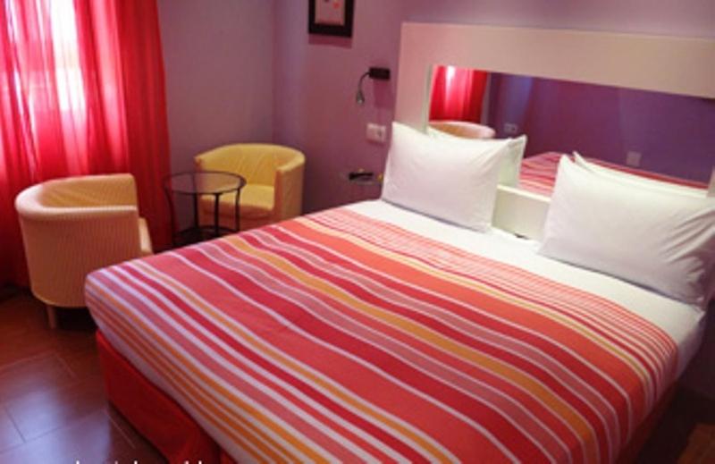 a hotel room with a large bed and two chairs at Hostal Arco Iris in Madrid