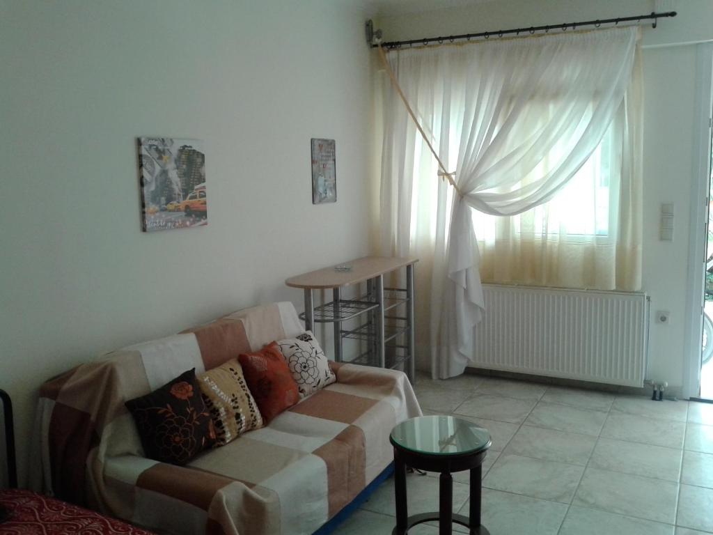 ein Wohnzimmer mit einem Sofa und einem Fenster in der Unterkunft Patra - Cute studio near center in Patras