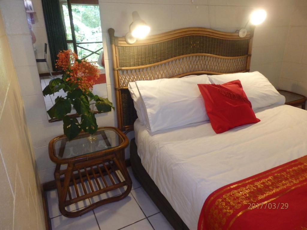 een kleine slaapkamer met een bed met een rood kussen bij Daintree Deep Forest Lodge in Cape Tribulation