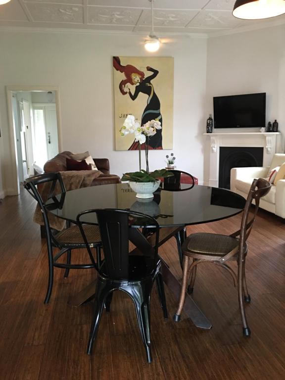 a living room with a table and chairs and a couch at Linda's Cottage @ the Hunter in Cessnock