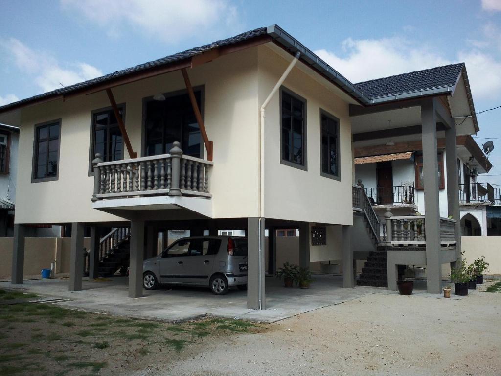 a house with a car parked in front of it at Teratak Tok Wan 1 and 2 in Kota Bharu
