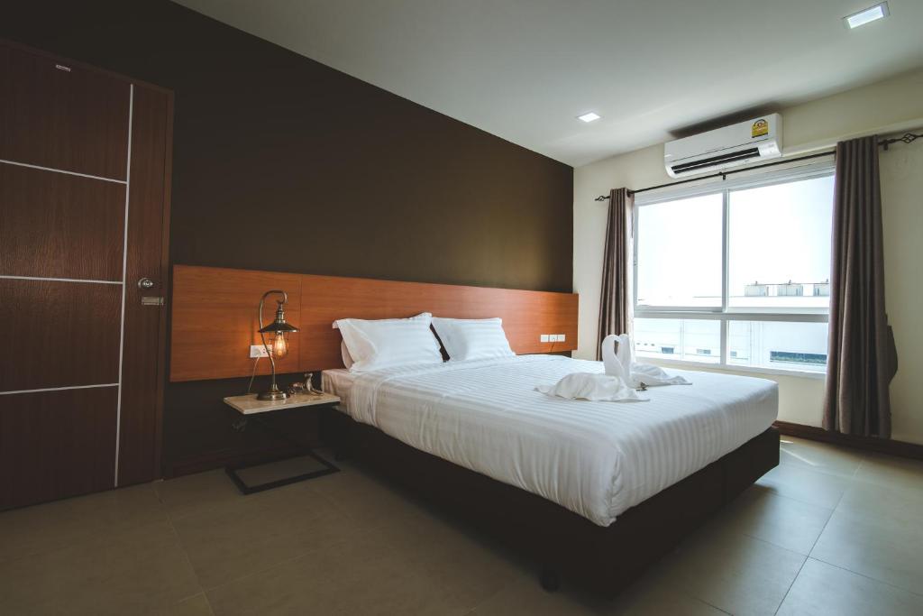 a bedroom with a large bed and a window at deVloft hotel Korat in Nakhon Ratchasima