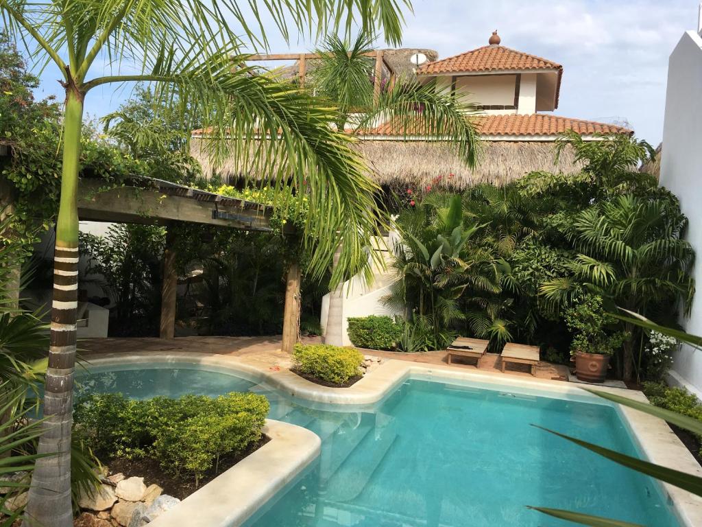 a swimming pool in a yard with a house at Villa Maria Bed and Breakfast in Puerto Escondido