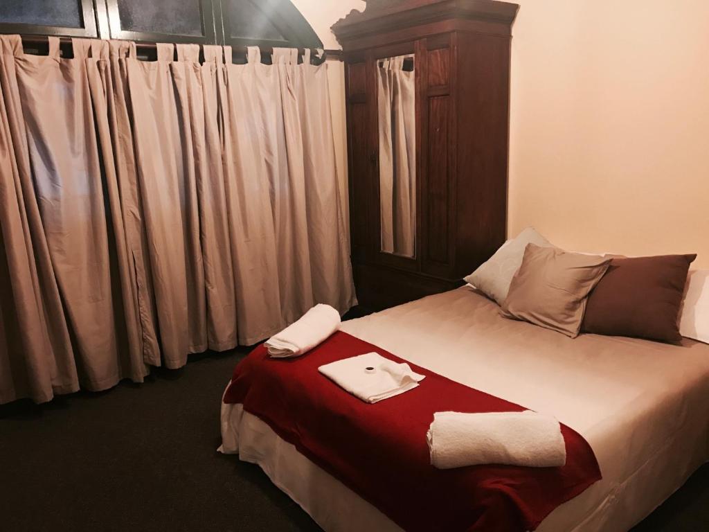 a hotel room with a bed and two lamps at Bellbird Hotel in Cessnock