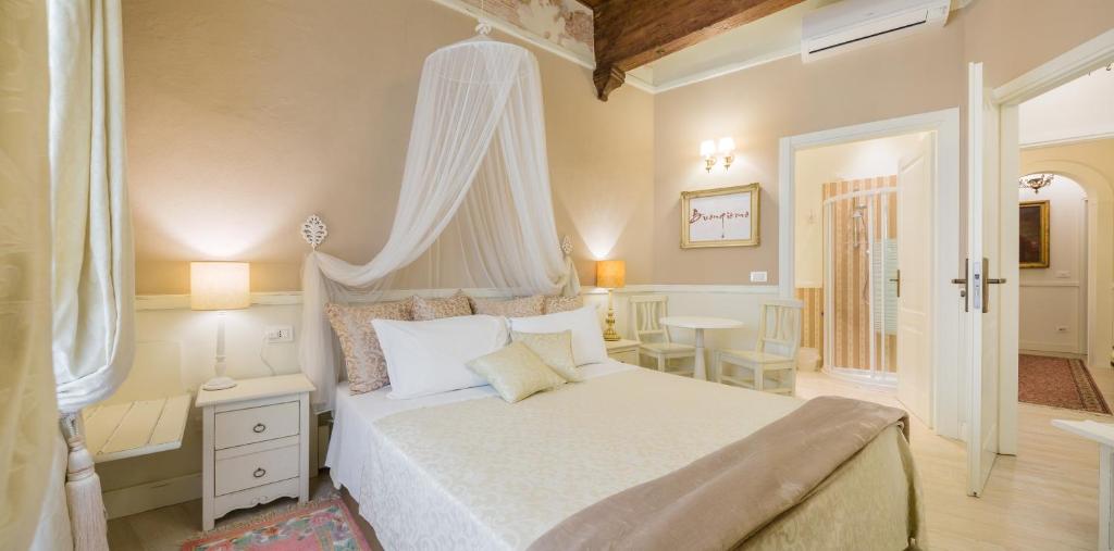 a bedroom with a white bed with a canopy at Vecchia Verona Rooms & Apartments in Verona