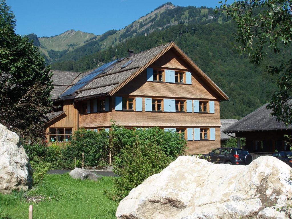 ein Holzhaus mit einem großen Felsen davor in der Unterkunft Küferhof in Mellau