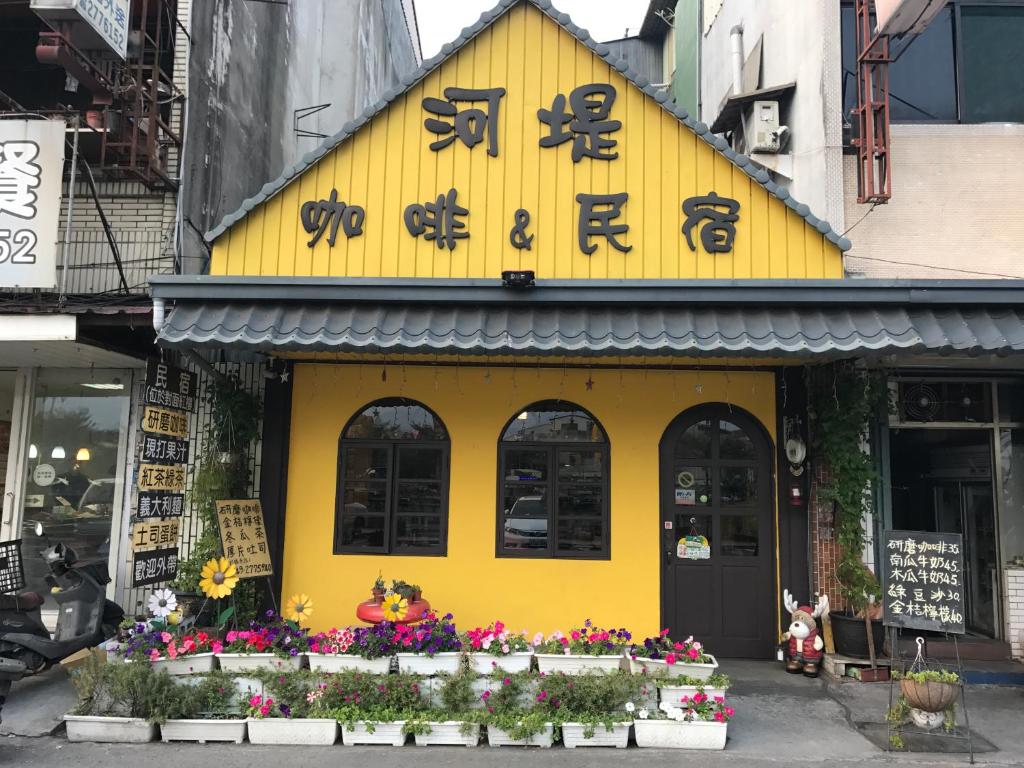 水里鄉的住宿－水里河堤咖啡民宿 Shuili Heti coffee B&B，黄色的建筑,有亚洲的书写