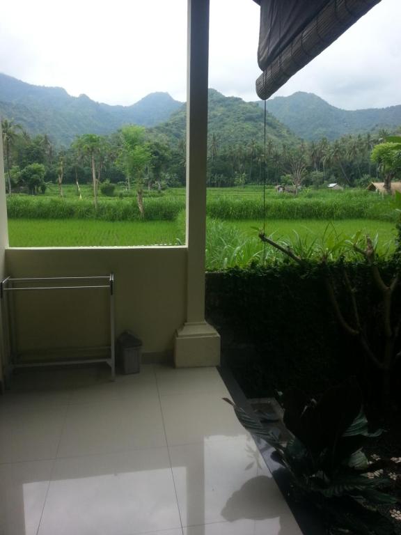 a room with a window with a view of a field at Lumbung Sari Home Stay in Amed