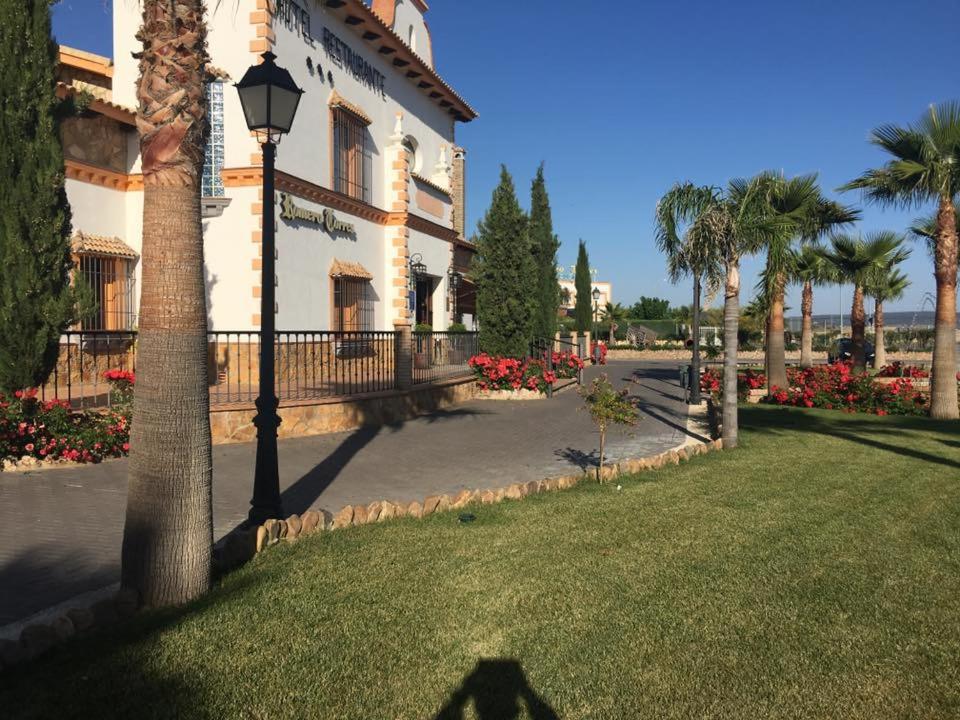 a large building with a large lawn and trees at Hotel Rural Romero Torres in Fuente Obejuna