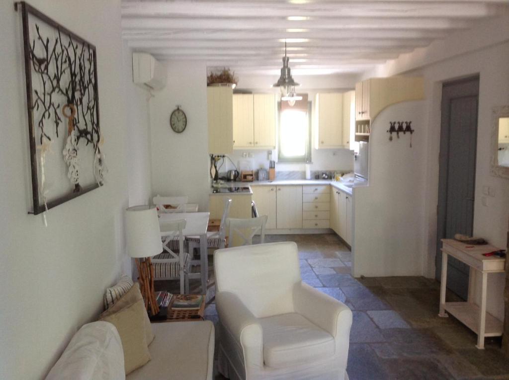 uma sala de estar com um sofá branco e uma cozinha em Summer dream , 5 min walk to the beach em Livadakia