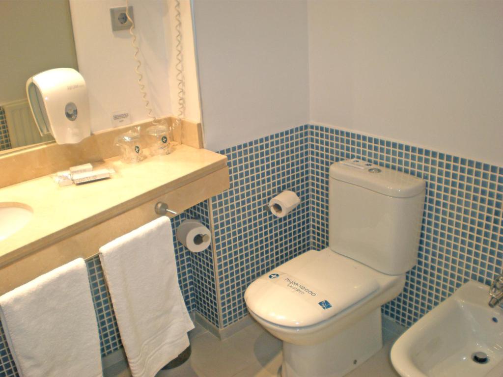 a bathroom with a toilet and a sink and a mirror at Hotel Murrieta in Logroño