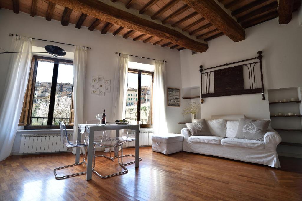 ein Wohnzimmer mit einem Tisch und einem Sofa in der Unterkunft Casa in Contrada in Siena