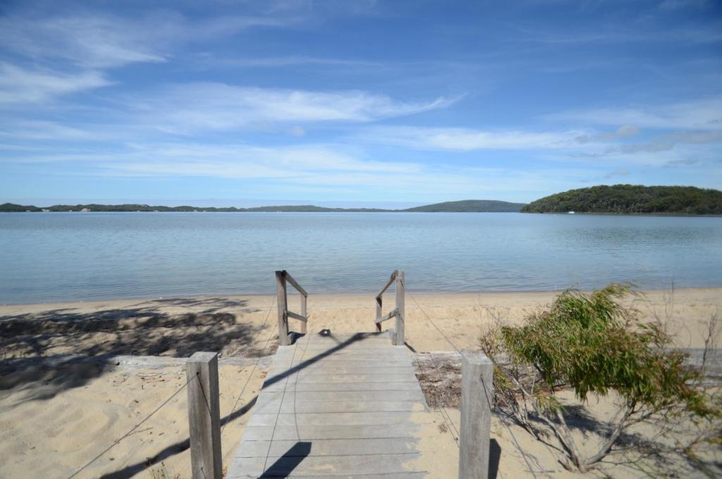 eine Holztreppe, die hinunter zu einem Sandstrand führt in der Unterkunft Coalmine Beach Holiday Park in Walpole