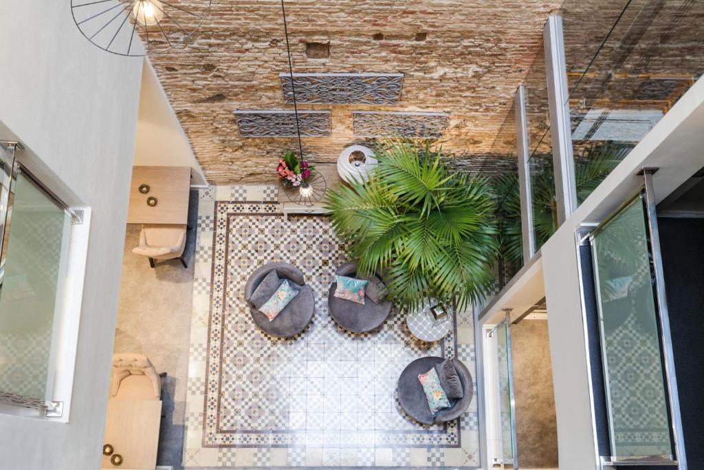 einen Blick über ein Zimmer mit Stühlen und einer Palme in der Unterkunft Hotel Palacete de Alamos in Málaga