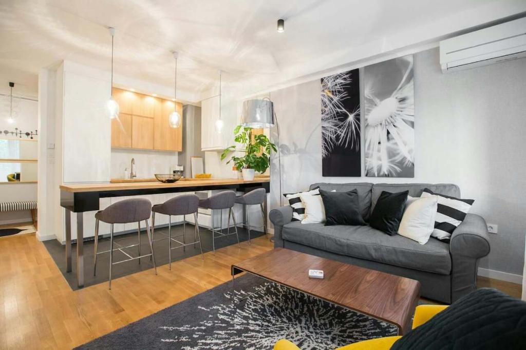 a living room and kitchen with a couch and a table at Hella Apartment in Zagreb
