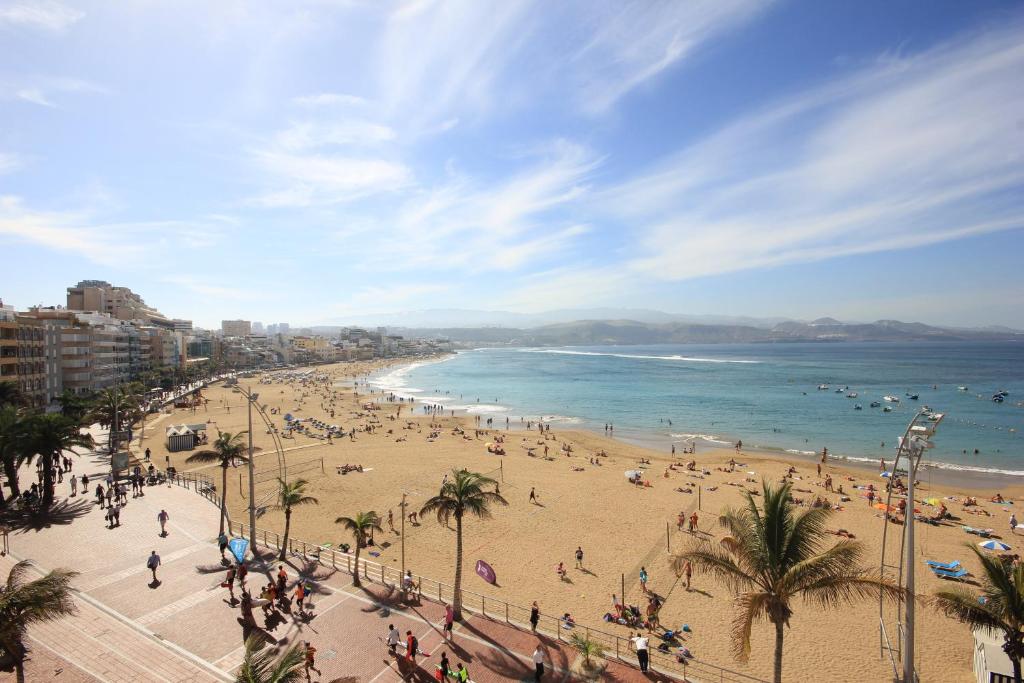 a beach with a lot of people and the ocean at Apartamentos Don Carlos in Las Palmas de Gran Canaria