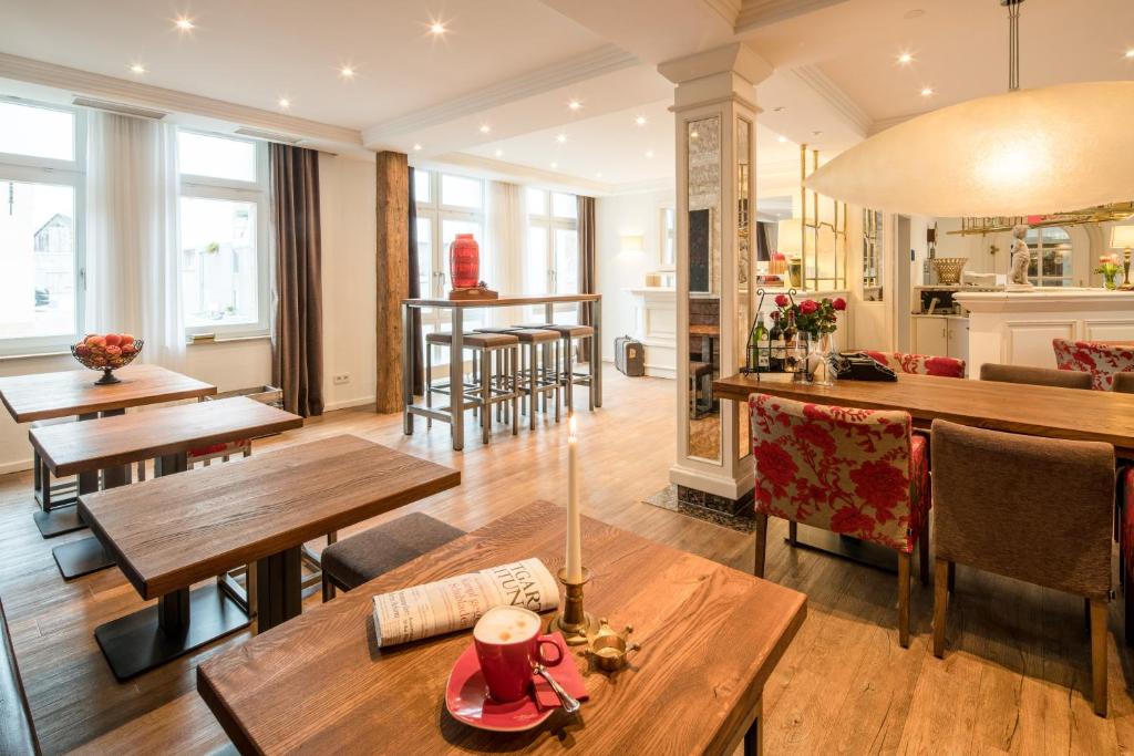 une salle à manger avec des tables et des chaises en bois dans l'établissement Weinstadt Hotel - das Original, à Weinstadt
