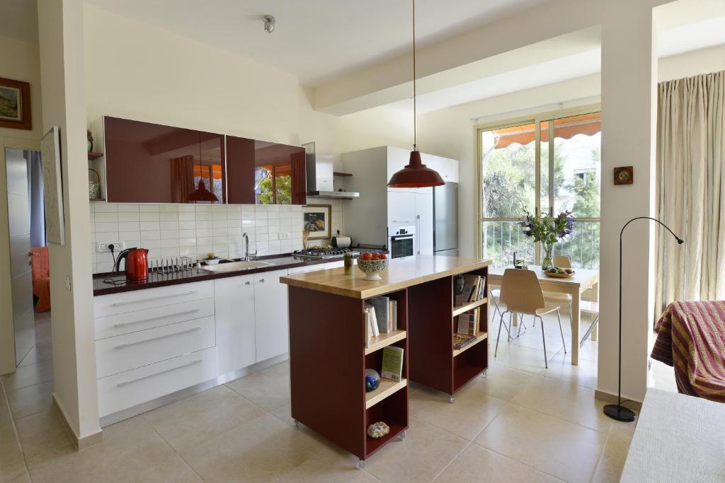 una cocina con armarios blancos y una mesa. en Ziv Apartments - Malkei Israel 6 A, en Tel Aviv