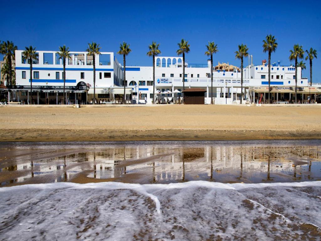 - une vue sur une plage bordée de palmiers et un bâtiment dans l'établissement Hotel Marlin Antilla Playa, à La Antilla