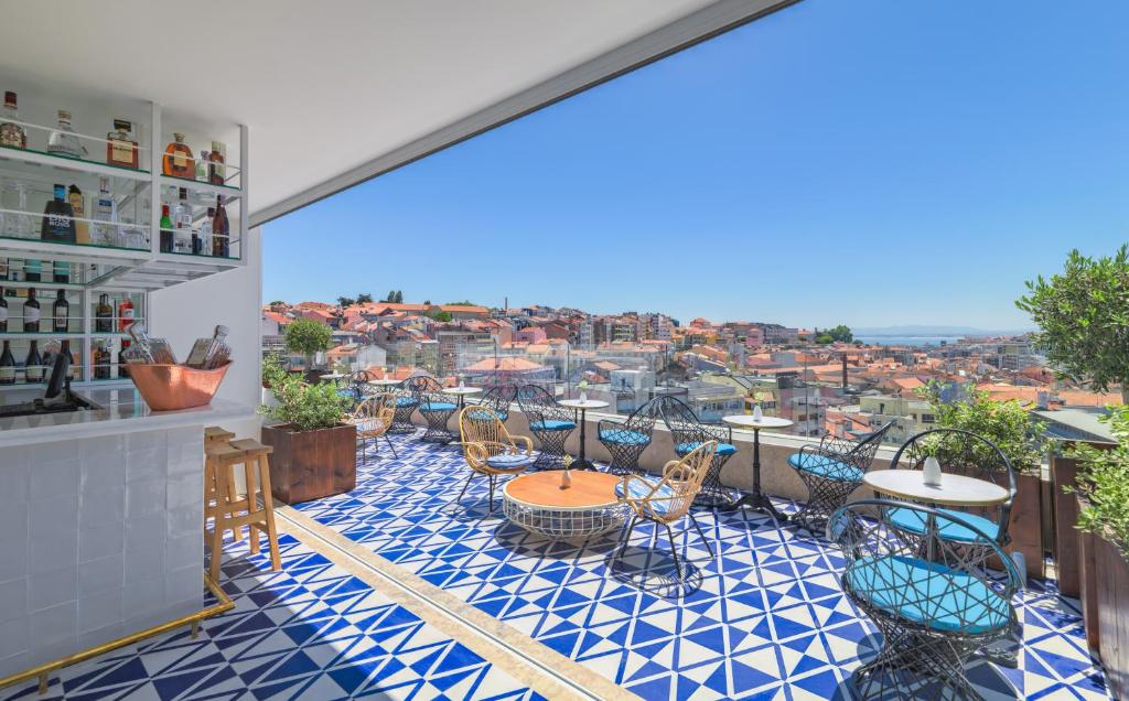 a patio with tables and chairs and a view of the city at H10 Duque de Loule in Lisbon