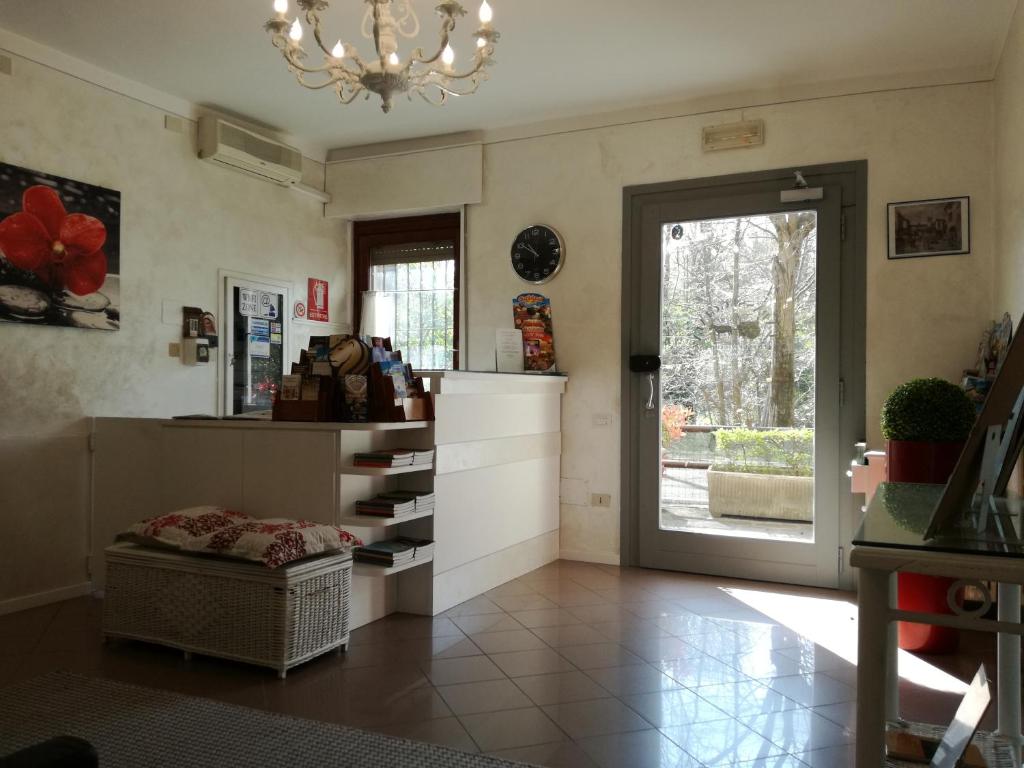 a living room with a chandelier and a door to a kitchen at Hotel La Passeggiata in Desenzano del Garda