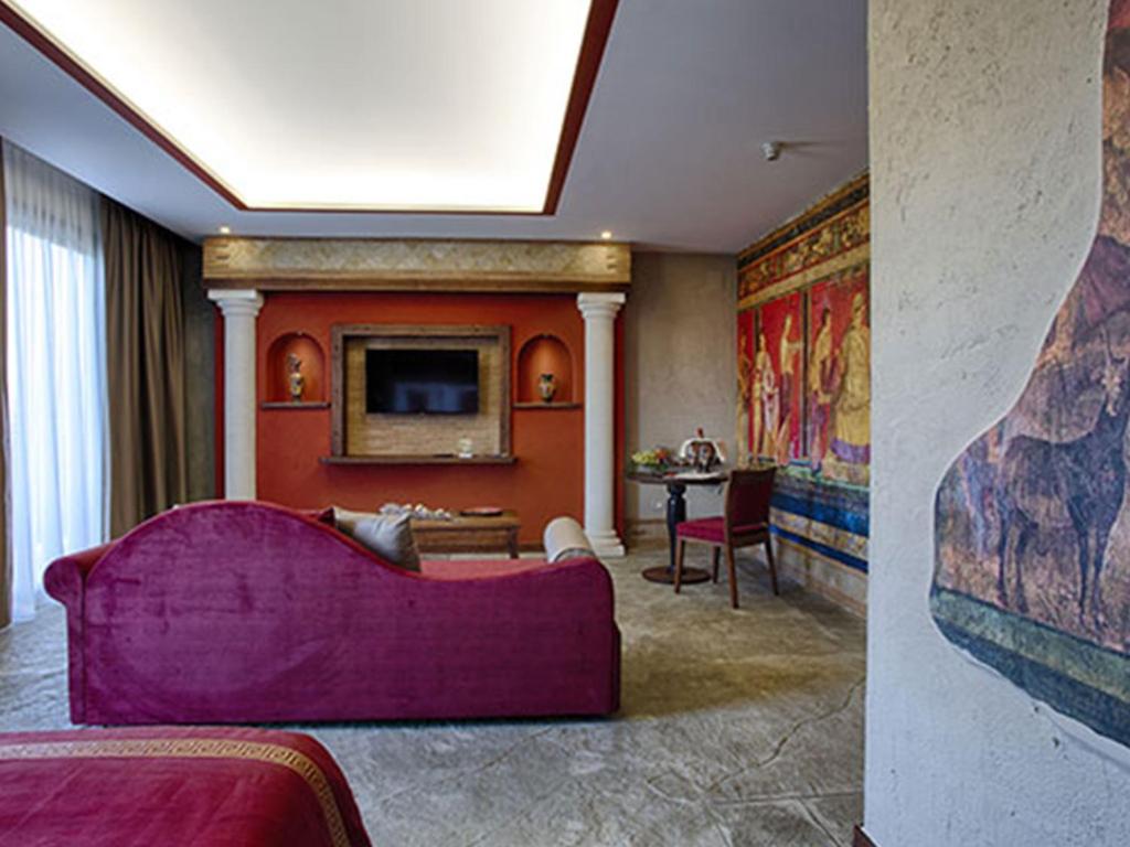 un soggiorno con divano viola e TV di Hotel del Sole a Pompei
