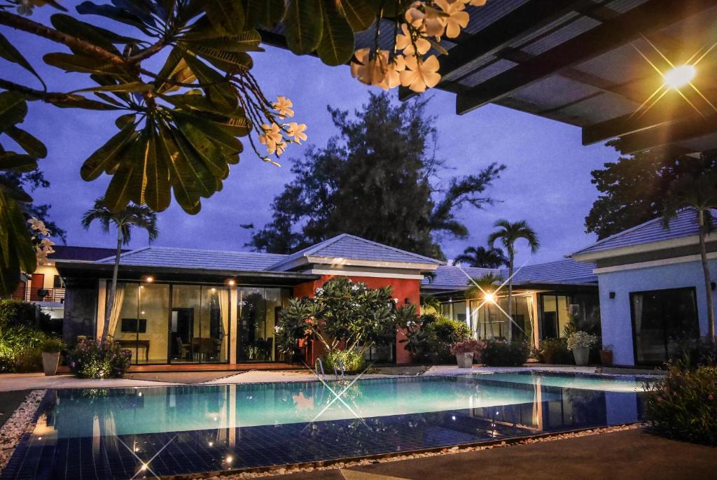 a villa with a swimming pool at night at Villa Navin in Jomtien Beach