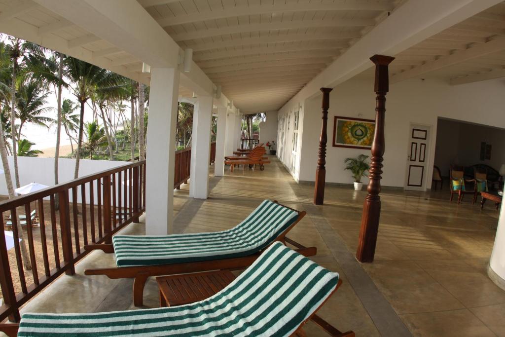 2 Stühle auf der Veranda eines Hauses in der Unterkunft Oasis Ayurveda Beach Hotel in Ambalangoda