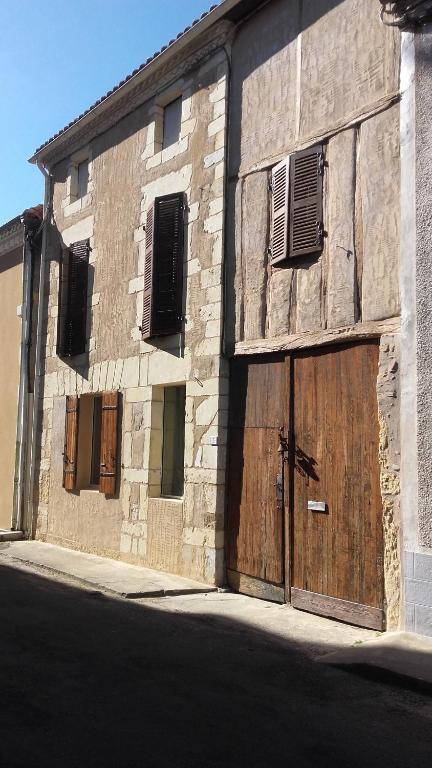 Samadetにあるchambres chez annickの大きな木製の扉のある古い石造りの建物