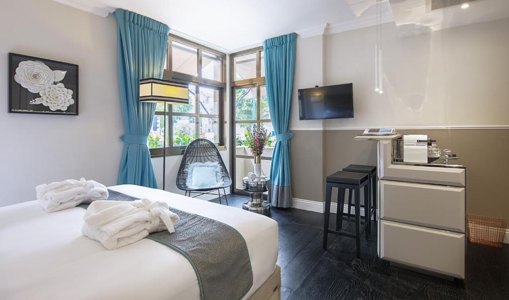 um quarto com uma cama, uma secretária e uma janela em A23 Boutique Hotel em Tel Aviv