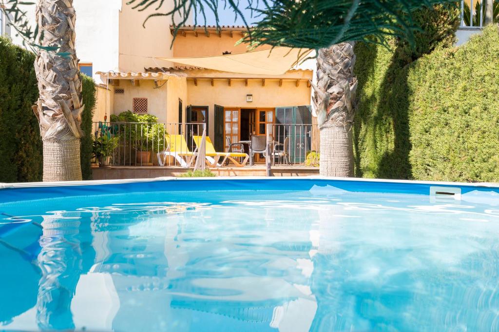 a swimming pool in front of a house at Can Olivera in Llubí