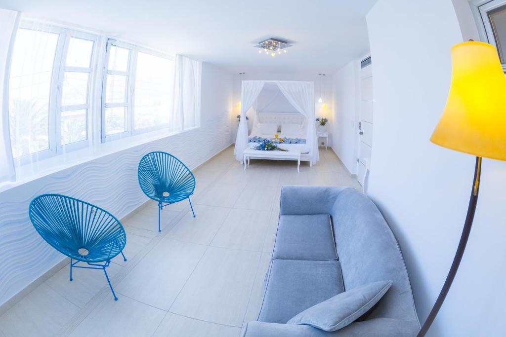 a living room with a blue couch and two chairs at Hydrele Beach Hotel & Village in Potokáki