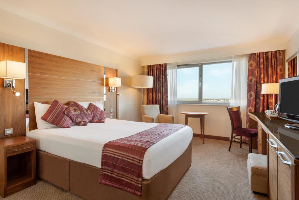 a hotel room with a large bed and a television at Waterfront Southport Hotel in Southport