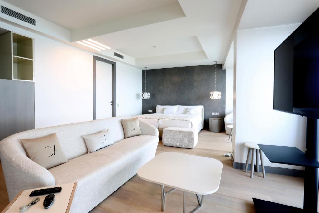 a living room with a white couch and a tv at Cosmo Apartments Platja d'Aro in Platja d'Aro