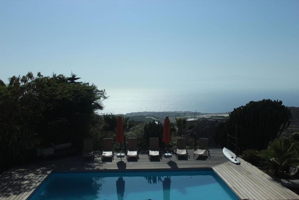 una piscina con sedie e vista sull'oceano di Casa Marbella Finca SanJuan Batista a Guía de Isora