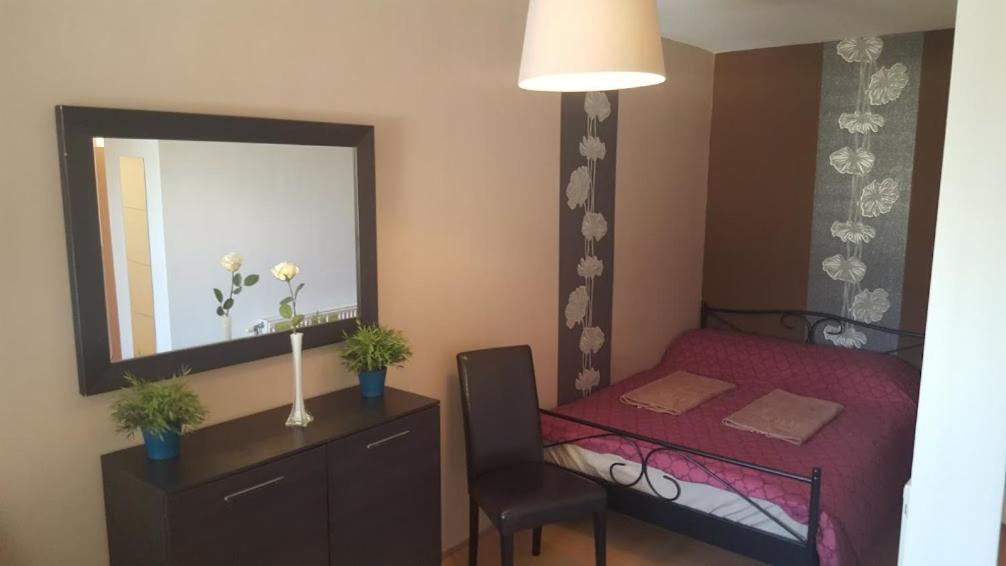 Csaba Apartment في بودابست: غرفة نوم صغيرة مع سرير احمر ومرآة