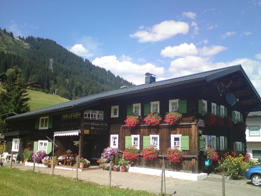 ein Gebäude mit Blumen davor in der Unterkunft Schusterhof in Mittelberg